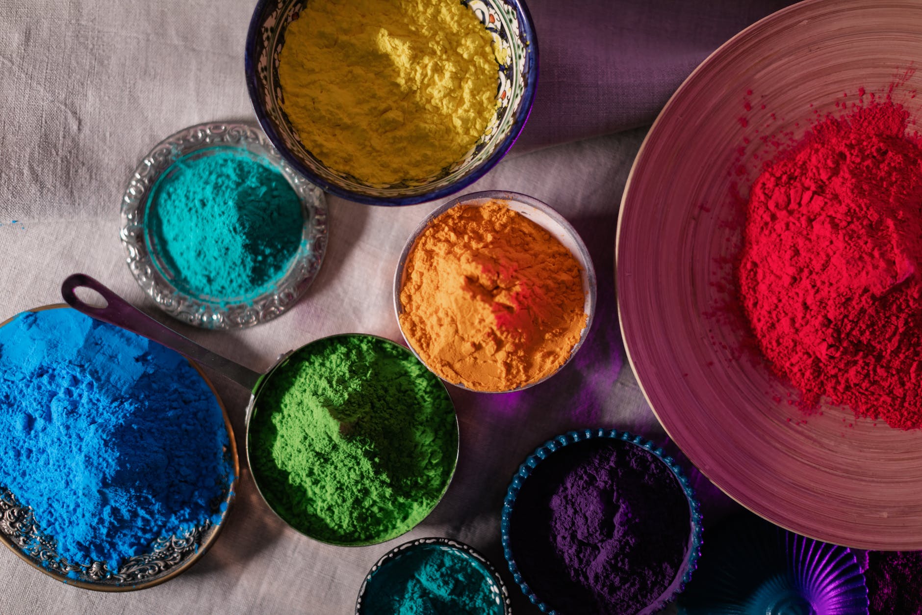 top view of multicoloured powders in bowls and plates
